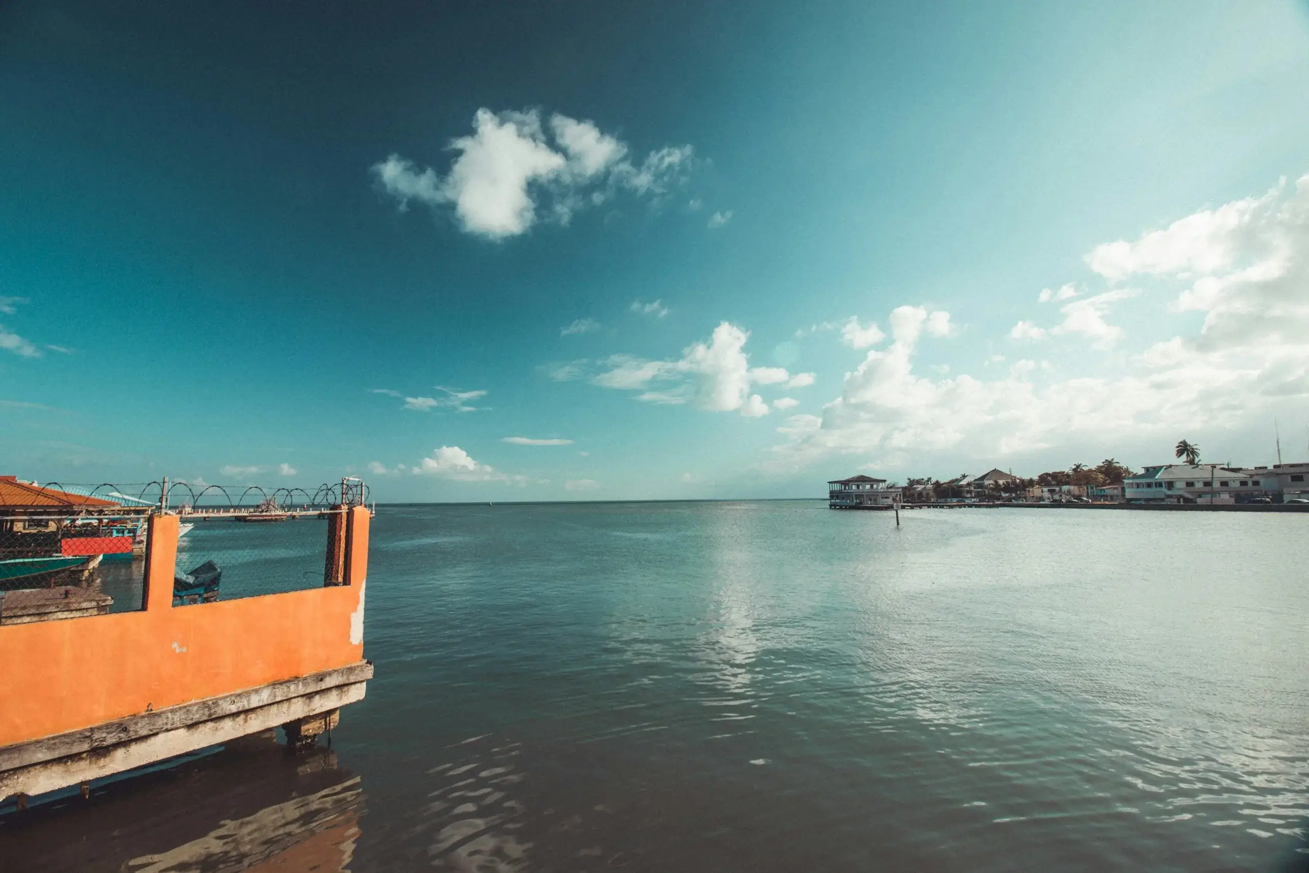 Calm turquoise sea off Belize City, with an orange pier in the foreground