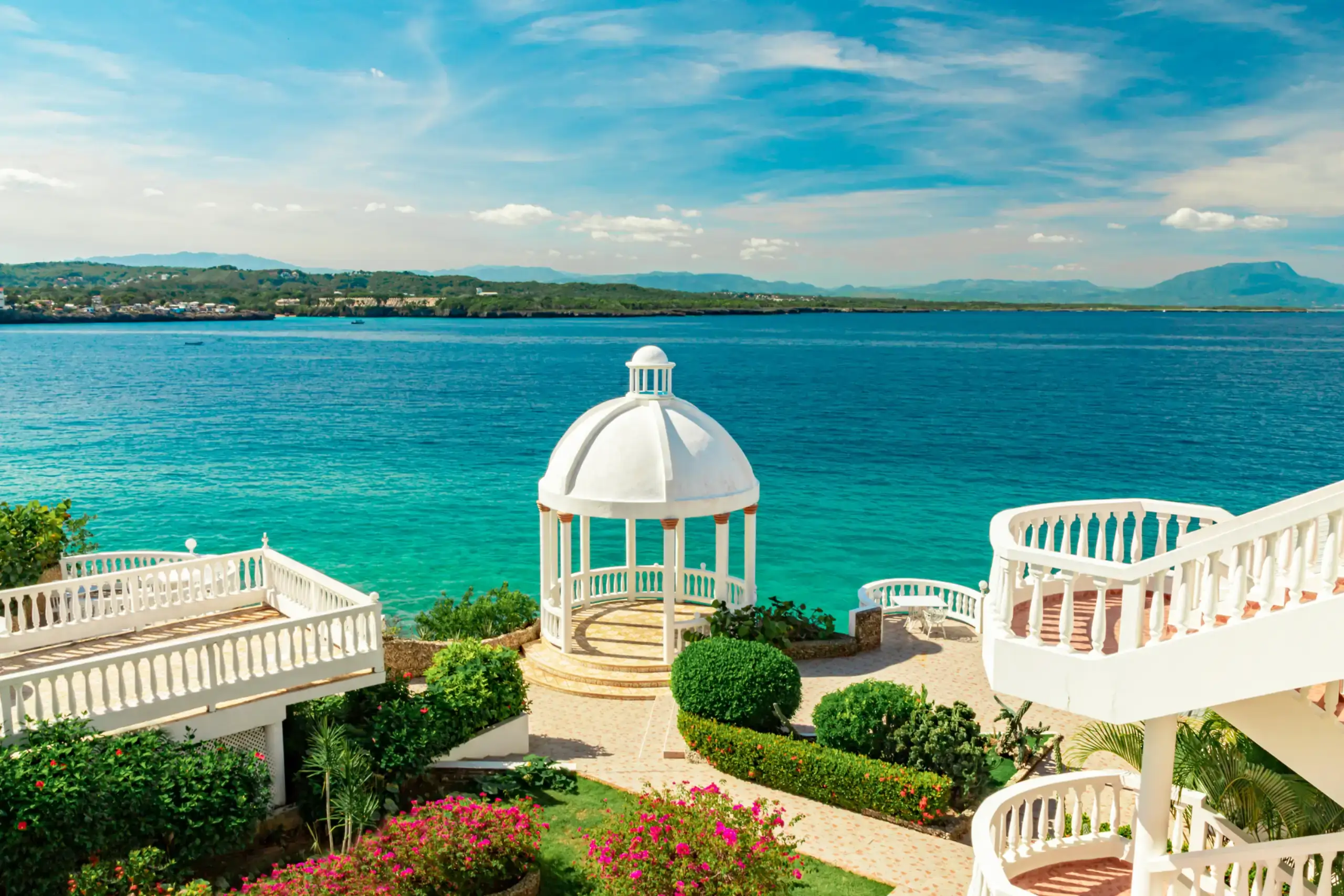 Une baie de sable courbe adossée à des collines vertes et des palmiers, Puerto Plata