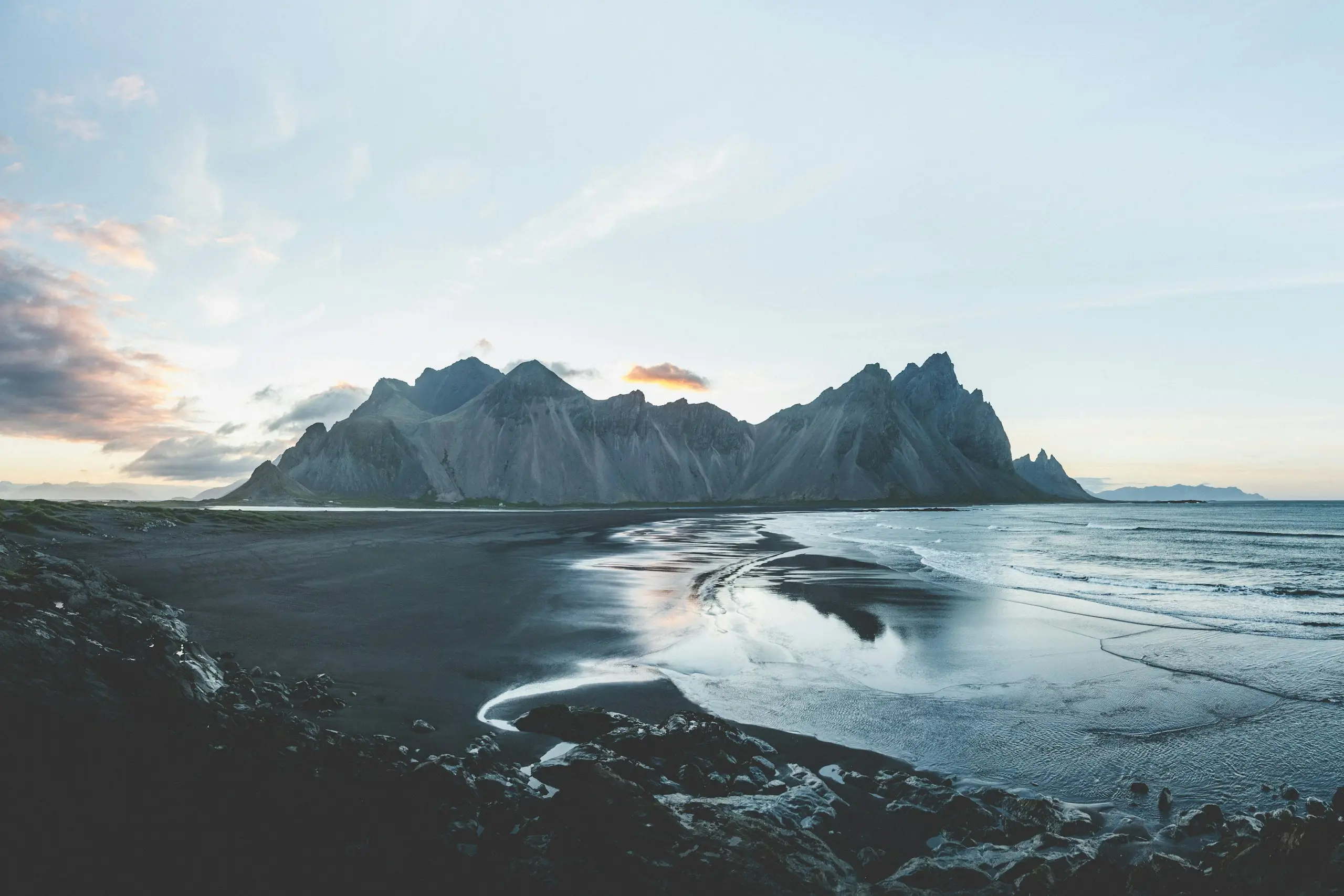 A black-sand shore and jagged mountains in Iceland