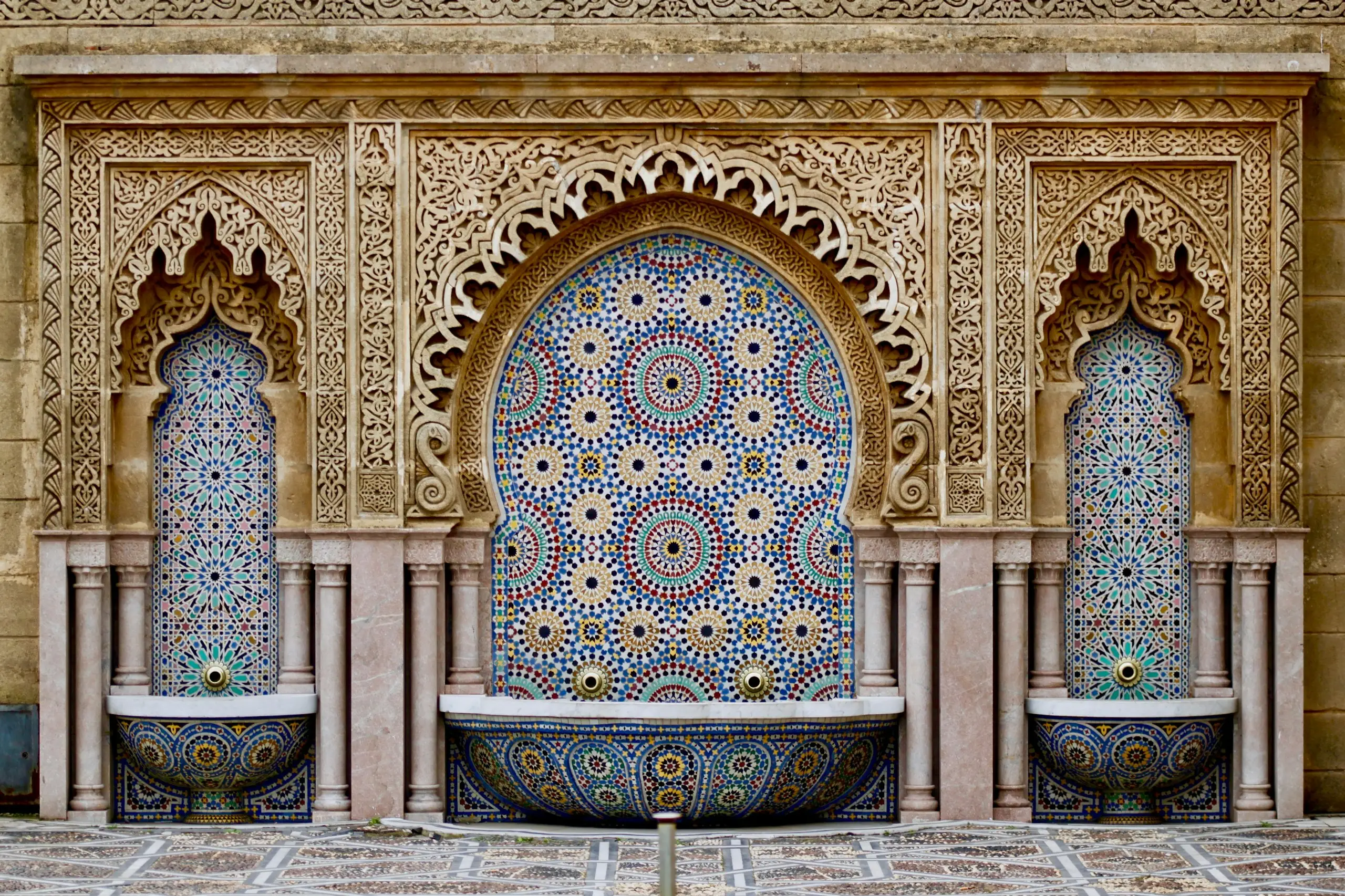 An ornate Moroccan tiled fountain with carved arches