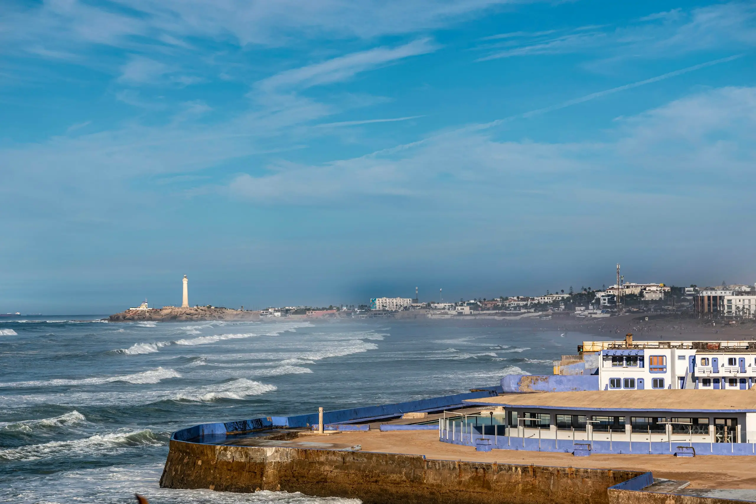 Waves breaking along the coast with a lighthouse beyond, Casablanca