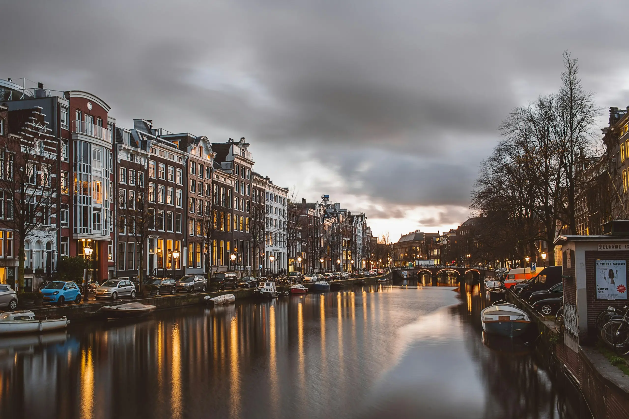 Des maisons à pignon le long d'un canal d'Amsterdam au crépuscule