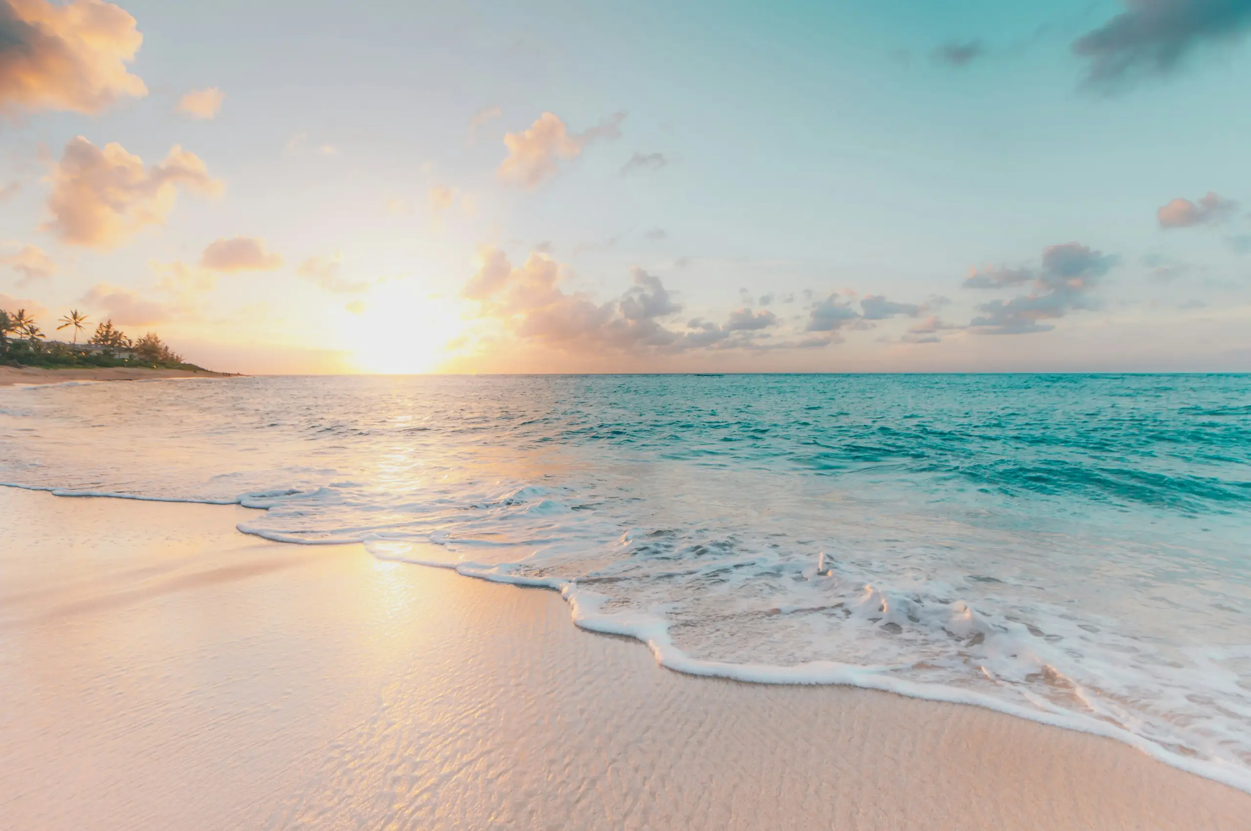 Gentle waves on a pale sandy beach at sunset, Panama