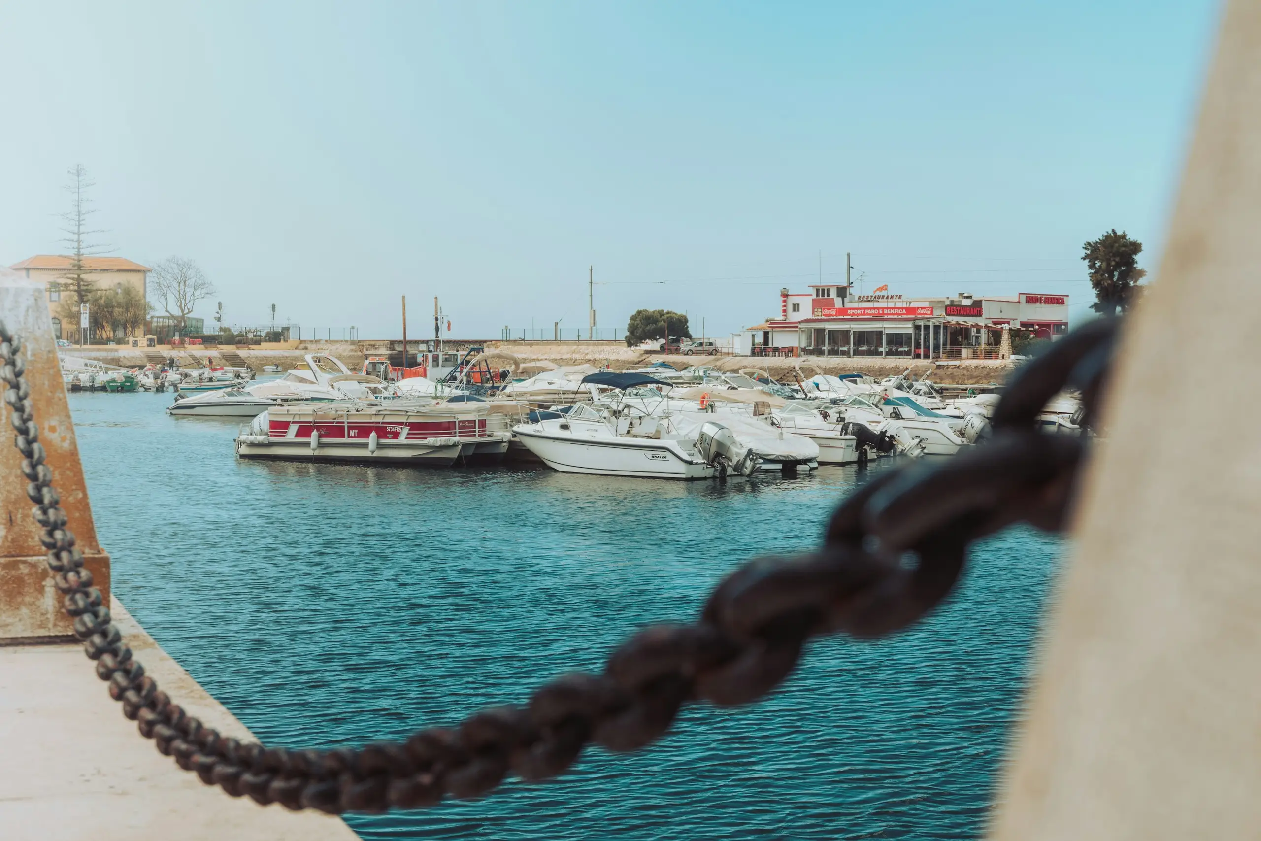 Boats moored in the marina beside waterfront restaurants, Faro, Portugal