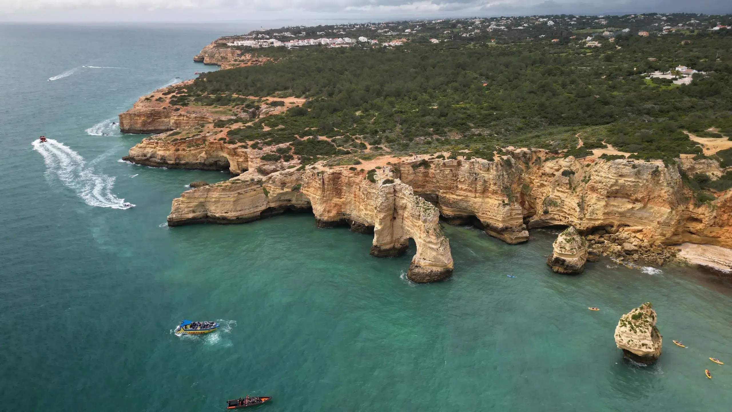 Aerial view of eroded sandstone cliffs and boats along the Algarve near Olhos de Água