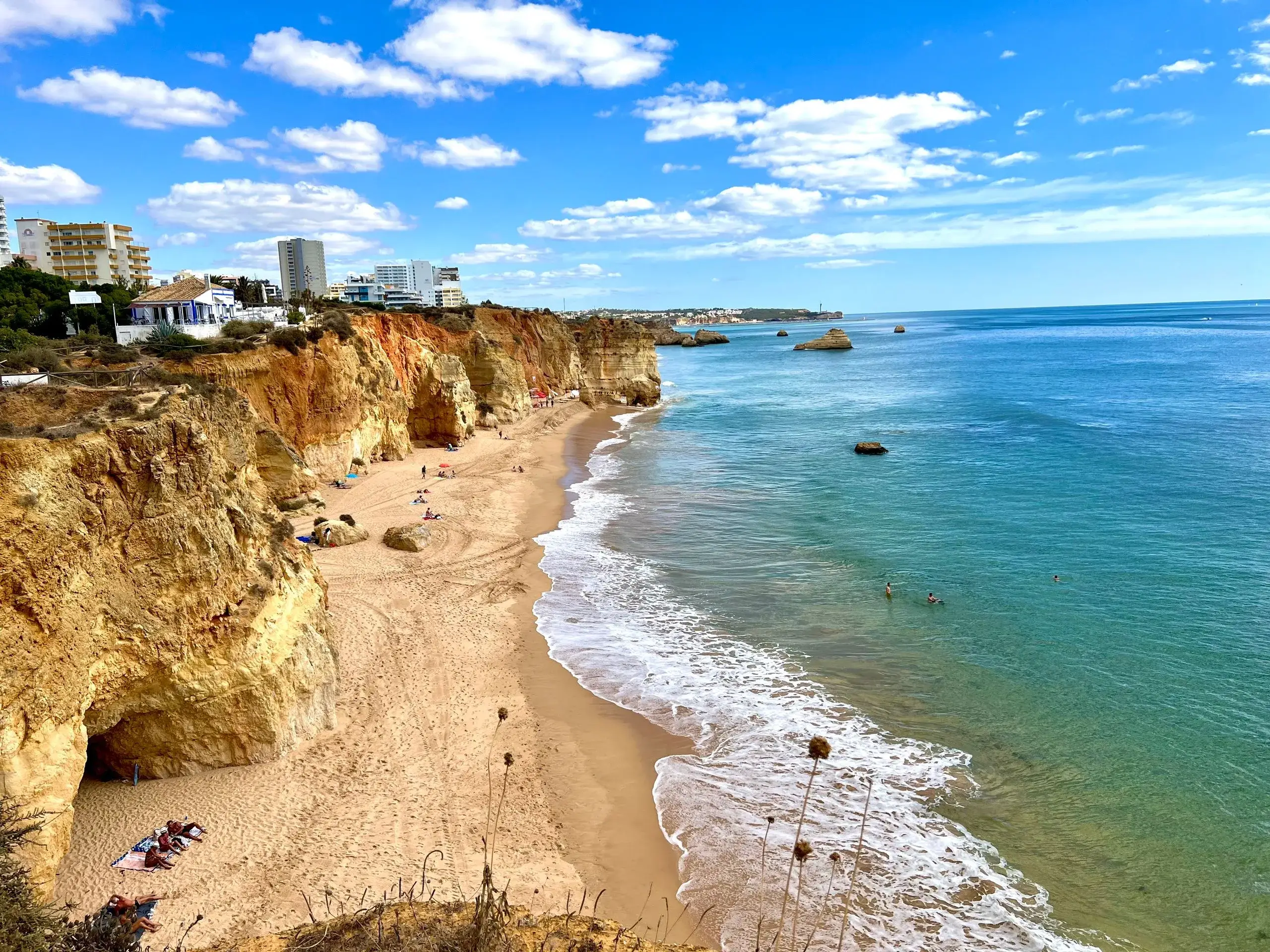 Golden cliffs above a sandy beach and turquoise sea in the Algarve near Vilamoura