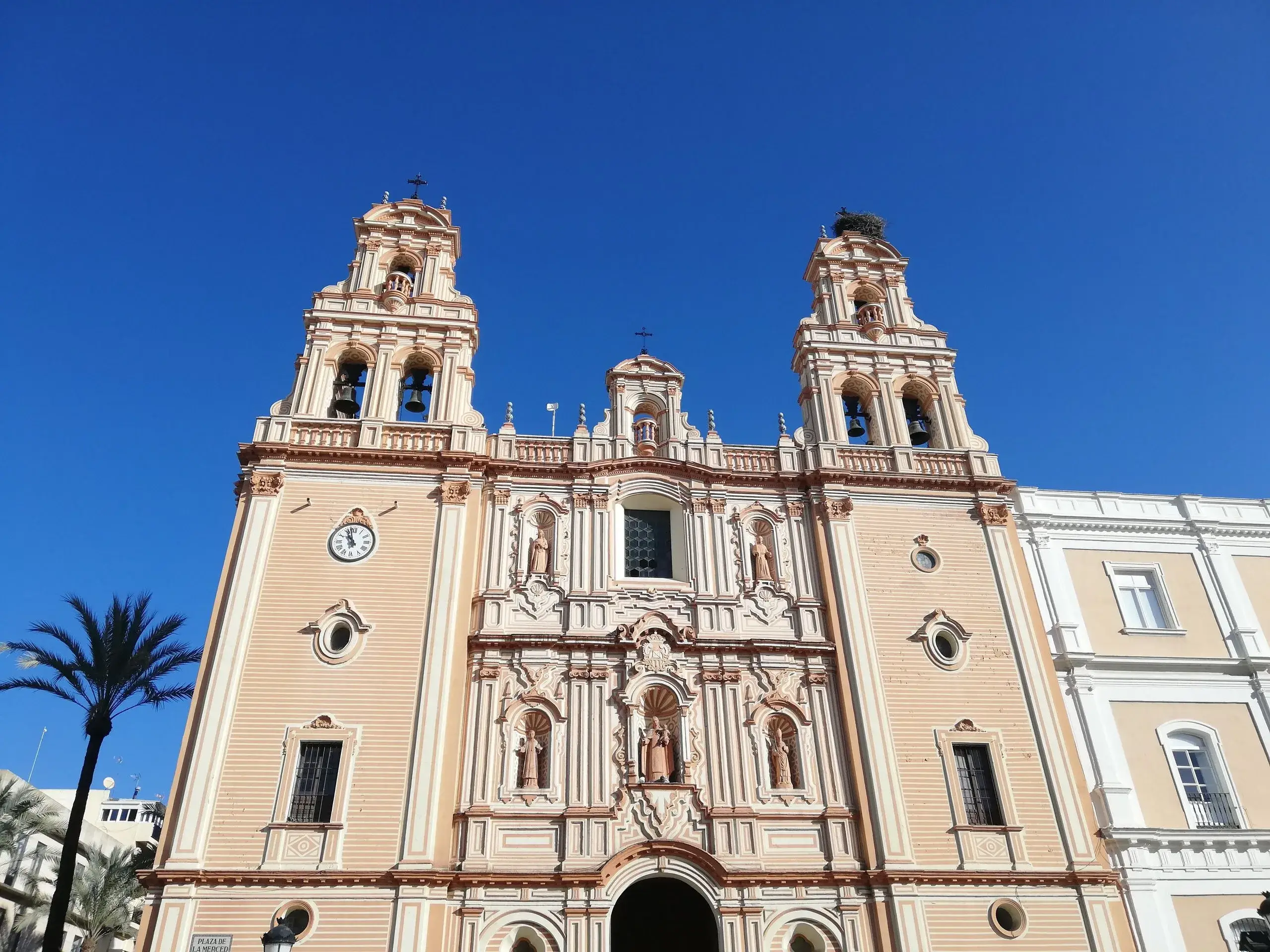 Baroque facade and twin towers of Huelva Cathedral against a blue sky
