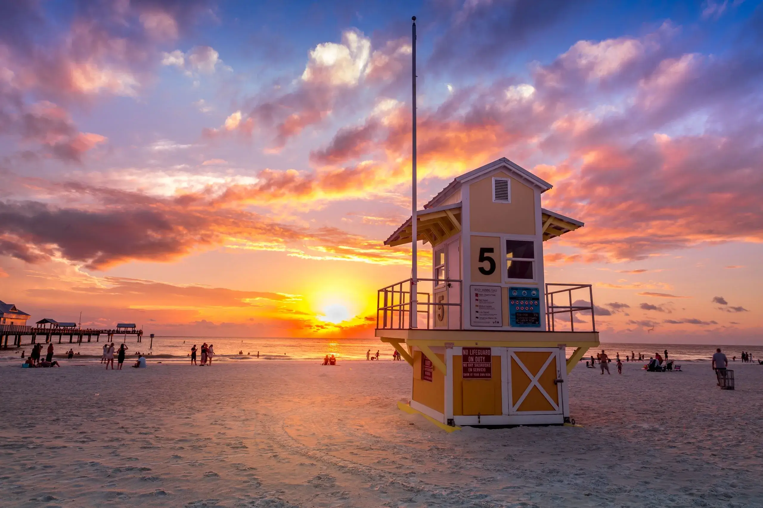 A lifeguard tower on Clearwater Beach under a vivid sunset sky