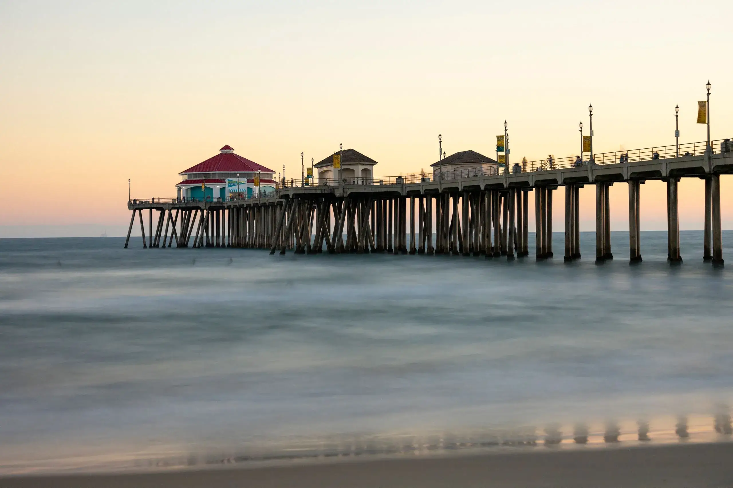 Huntington Beach Pier stretching over calm water at dusk