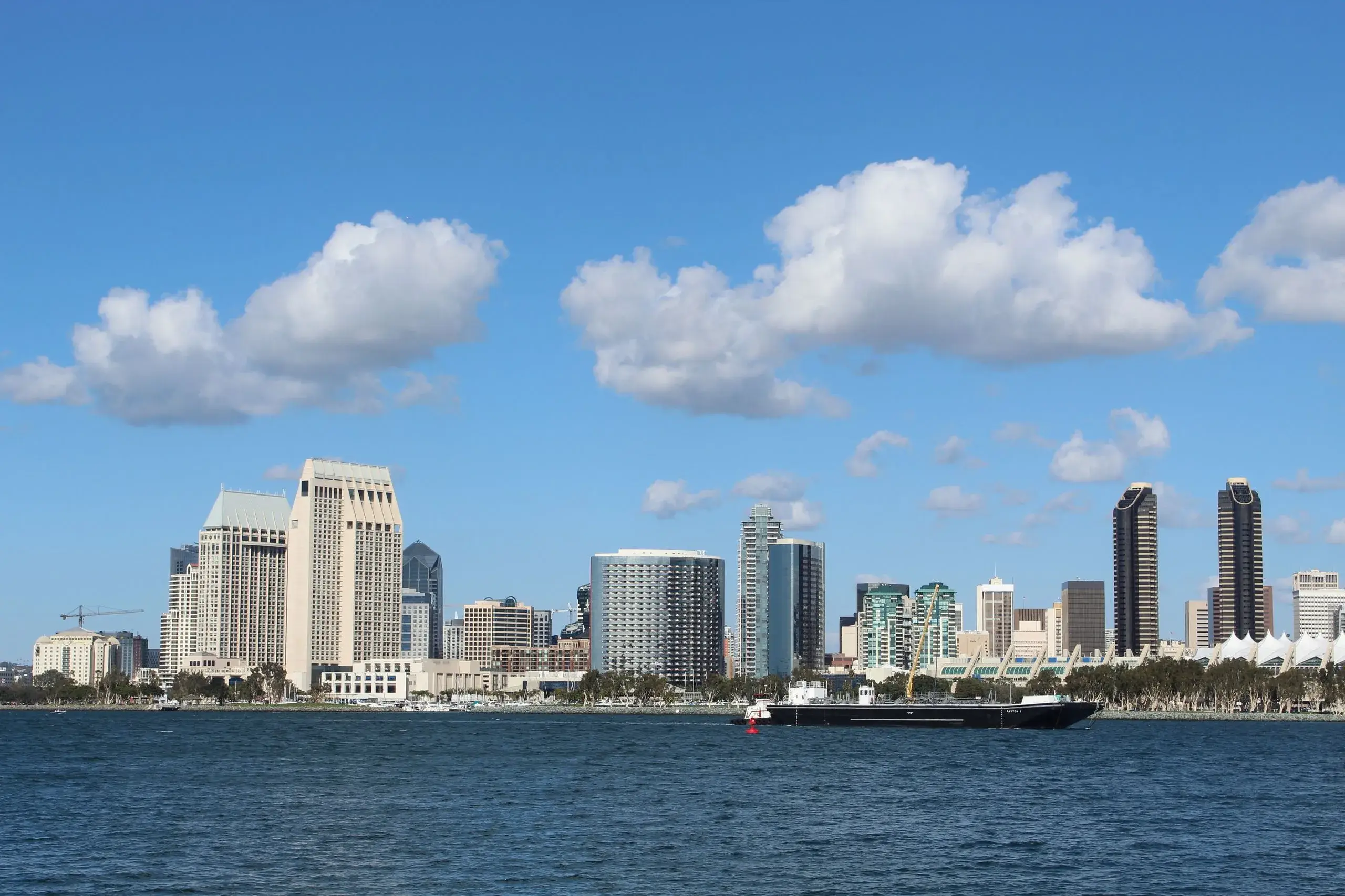 The San Diego skyline across the bay under blue sky