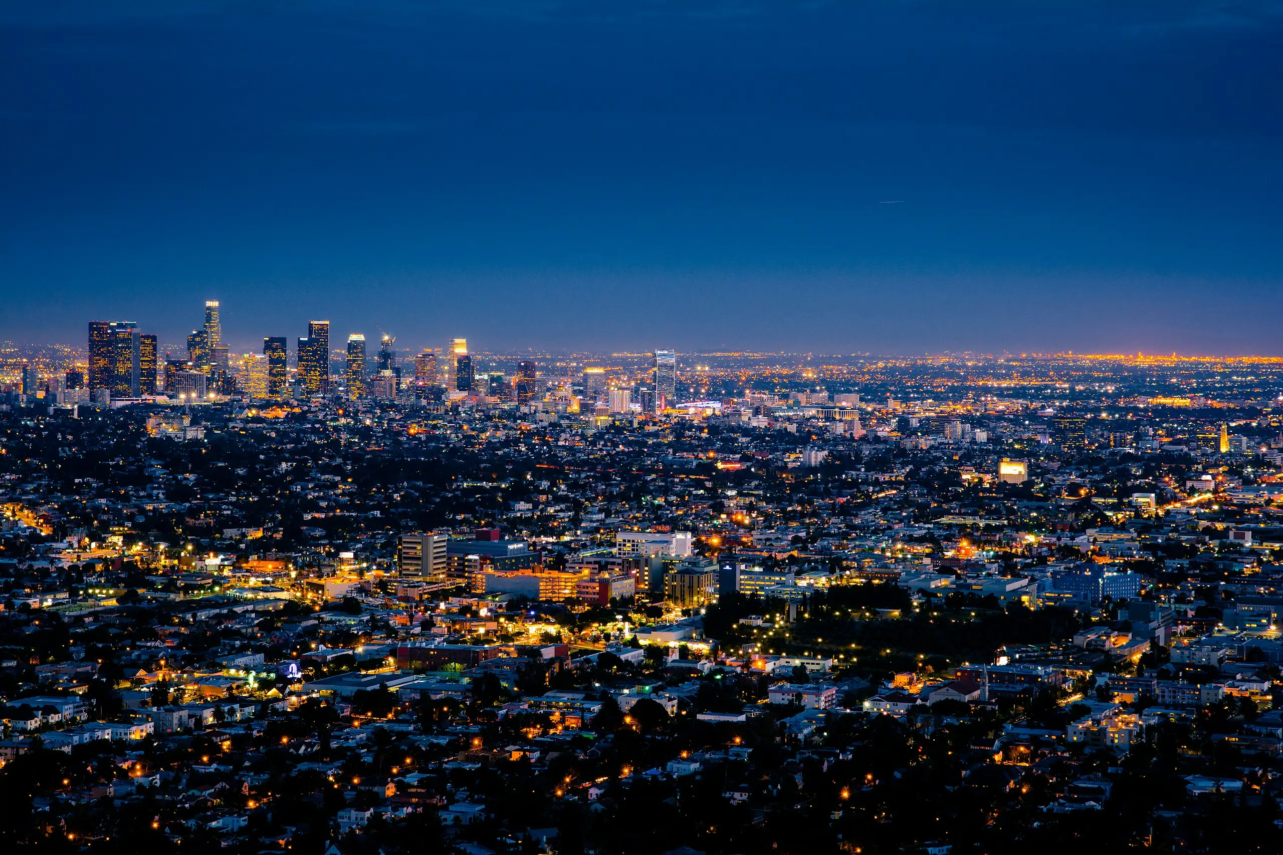 The Los Angeles skyline glowing at dusk, seen near West Hollywood, California